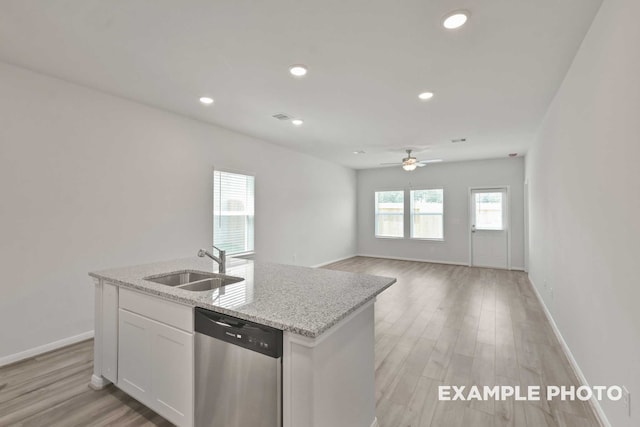 kitchen featuring sink, a center island with sink, stainless steel dishwasher, and light wood-type flooring