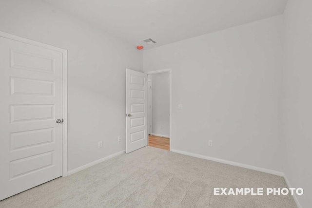 unfurnished room featuring light colored carpet