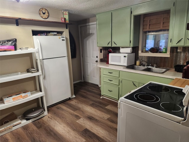 kitchen with sink, dark hardwood / wood-style floors, a textured ceiling, white appliances, and green cabinetry