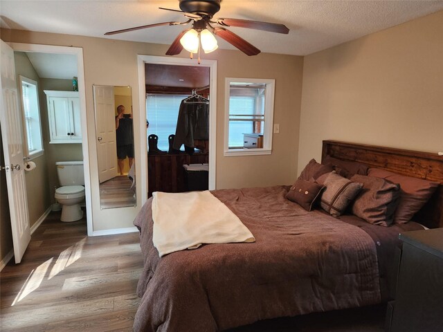 bedroom with a textured ceiling, ceiling fan, hardwood / wood-style flooring, connected bathroom, and a closet