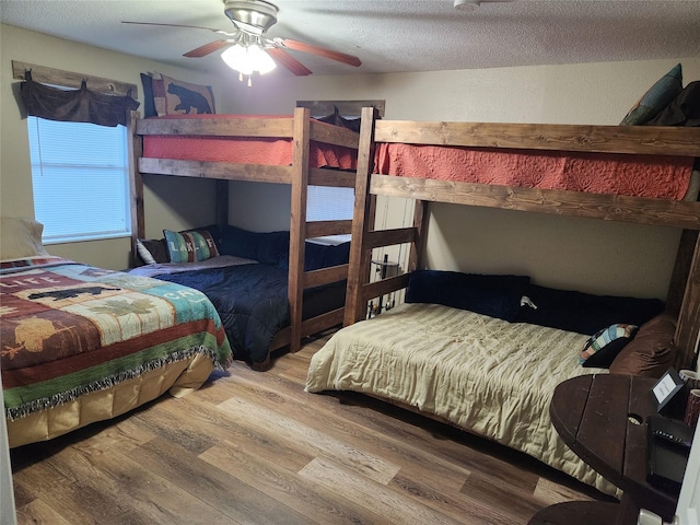 bedroom with hardwood / wood-style floors, a textured ceiling, and ceiling fan