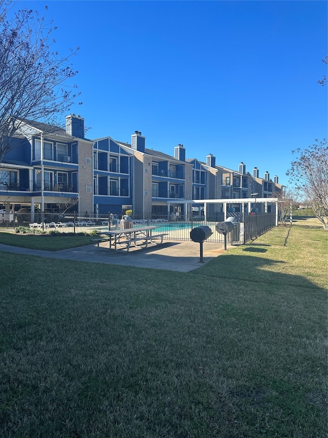 surrounding community with a swimming pool, a yard, and a patio area