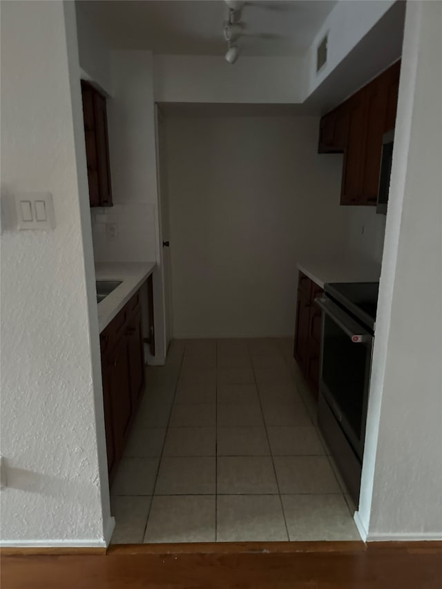 kitchen featuring electric range oven and light tile patterned floors