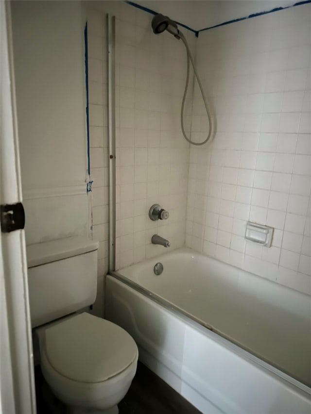 bathroom featuring tiled shower / bath combo and toilet