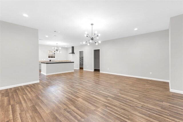 unfurnished living room featuring a chandelier and hardwood / wood-style flooring