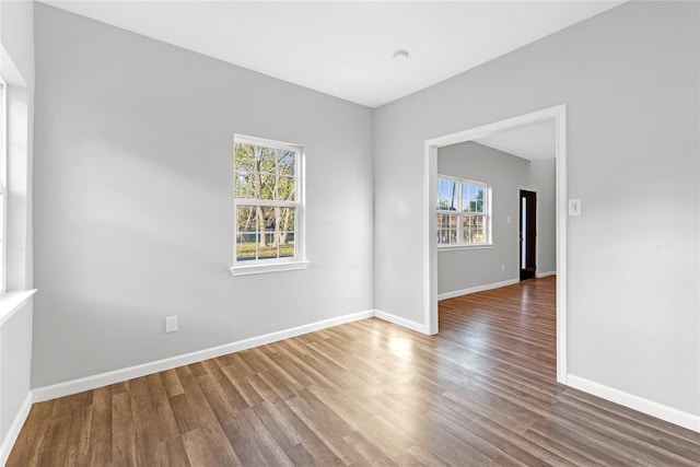 unfurnished room featuring plenty of natural light and hardwood / wood-style floors