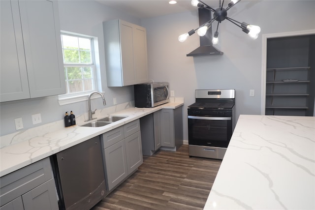 kitchen with gray cabinets, dark hardwood / wood-style flooring, light stone counters, sink, and appliances with stainless steel finishes