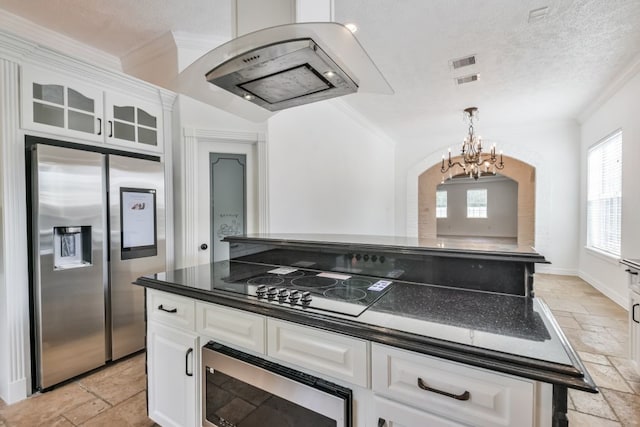 kitchen featuring crown molding, appliances with stainless steel finishes, light tile flooring, white cabinetry, and a chandelier