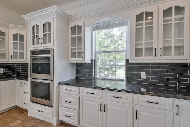 kitchen with ornamental molding, white cabinets, tasteful backsplash, and double oven