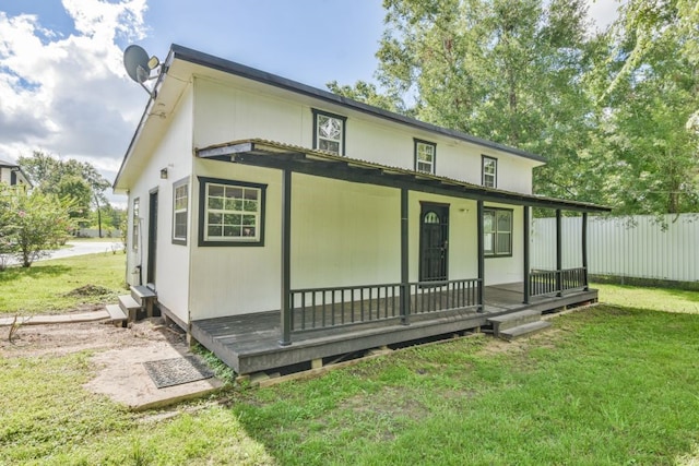 rear view of house with a lawn and a porch