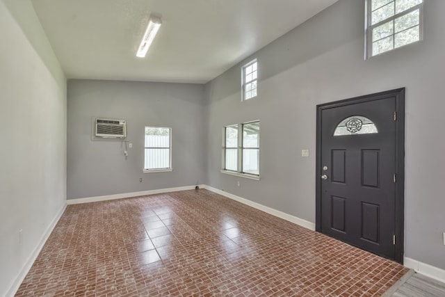 tiled entryway featuring a high ceiling and a wall unit AC