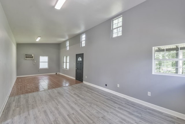 entrance foyer with a wealth of natural light, a towering ceiling, and light tile floors