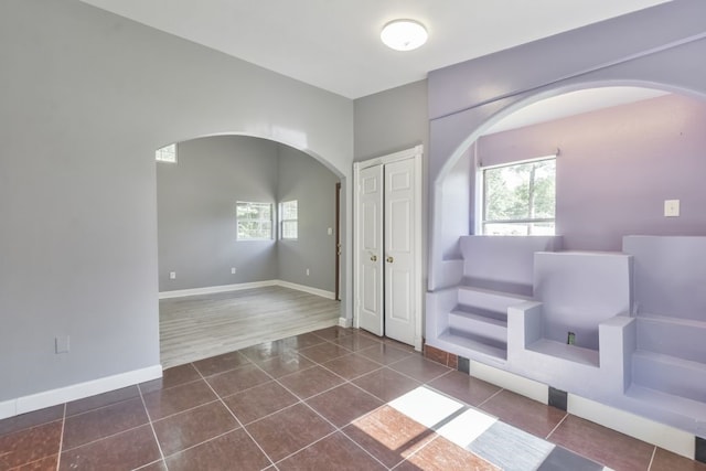 unfurnished room featuring dark tile flooring