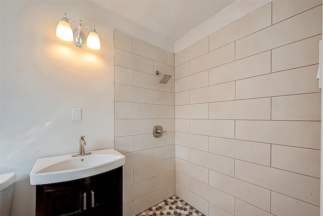 bathroom with vanity, toilet, and a tile shower