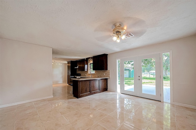 kitchen featuring french doors, ceiling fan, dark brown cabinetry, tasteful backsplash, and kitchen peninsula