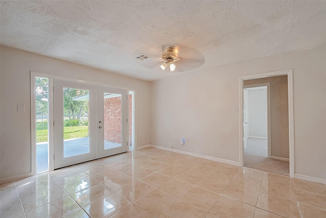 spare room with ceiling fan, french doors, light tile patterned floors, and a textured ceiling