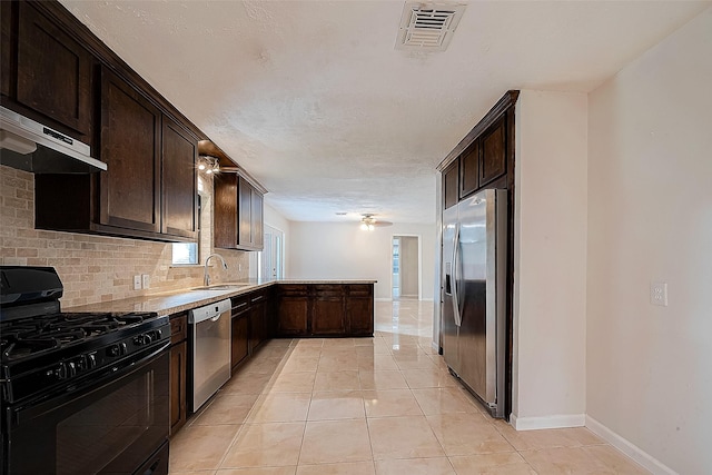 kitchen with dark brown cabinetry, stainless steel appliances, tasteful backsplash, and sink