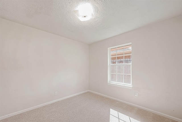 carpeted empty room with a textured ceiling