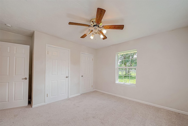 unfurnished bedroom with light carpet and ceiling fan