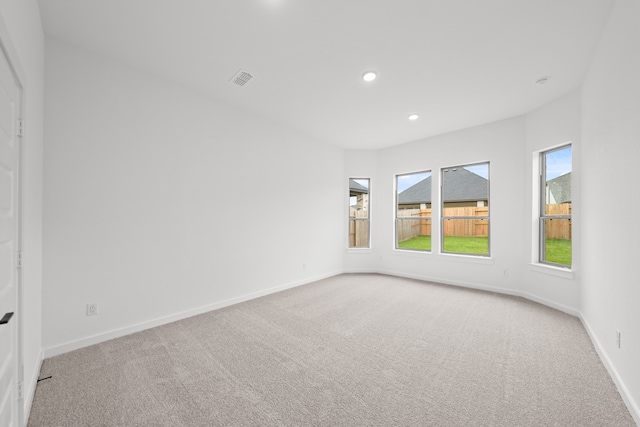 spare room featuring light colored carpet