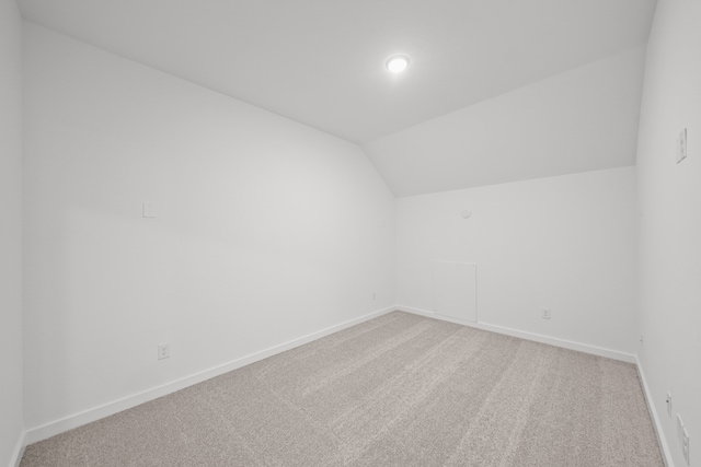 bonus room with vaulted ceiling and carpet floors