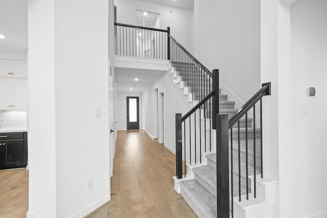 stairs featuring a high ceiling and wood-type flooring