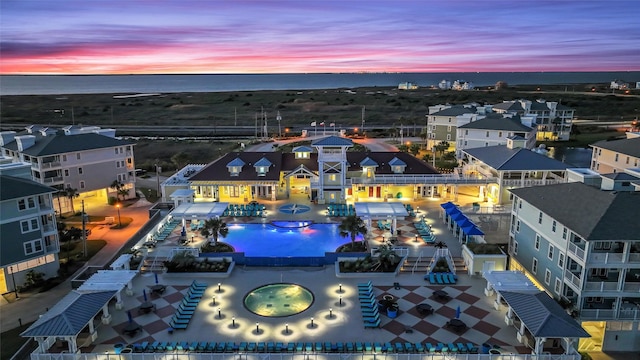 aerial view at dusk featuring a water view