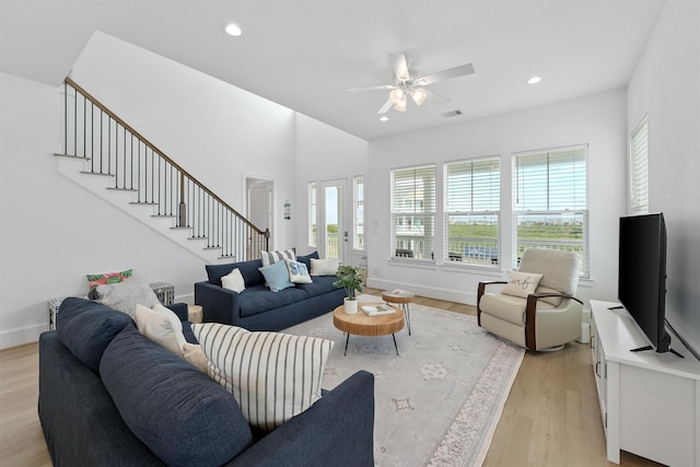 living room with ceiling fan and light hardwood / wood-style flooring