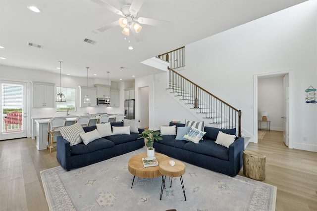 living room with ceiling fan and light hardwood / wood-style flooring