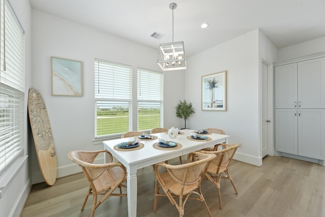 dining room featuring light hardwood / wood-style floors and a chandelier