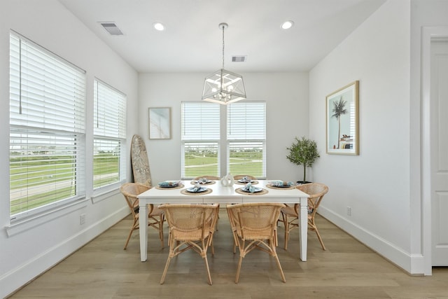 dining room with a notable chandelier and light wood-type flooring