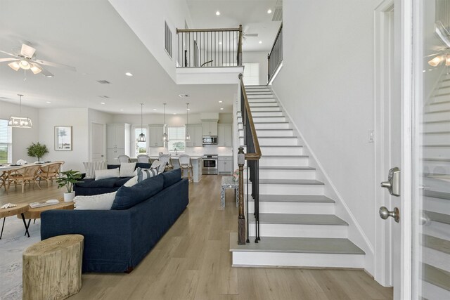 stairs with ceiling fan and hardwood / wood-style floors