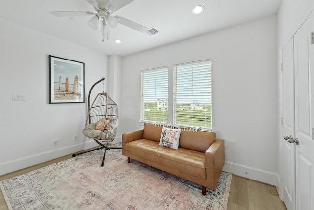 sitting room with ceiling fan and light hardwood / wood-style flooring