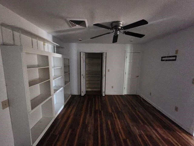 empty room with ceiling fan, a textured ceiling, and dark hardwood / wood-style flooring