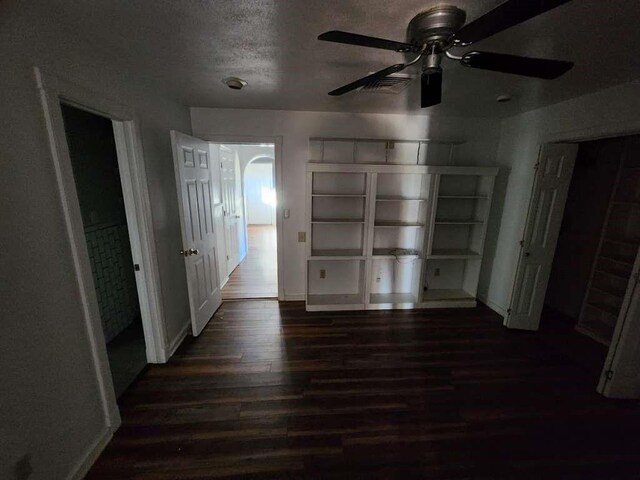 unfurnished bedroom featuring ceiling fan, dark hardwood / wood-style floors, and a textured ceiling