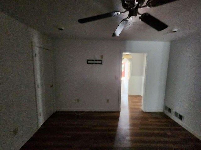 unfurnished room with ceiling fan and dark hardwood / wood-style flooring