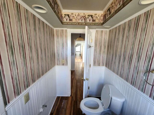 bathroom featuring hardwood / wood-style floors, crown molding, and toilet