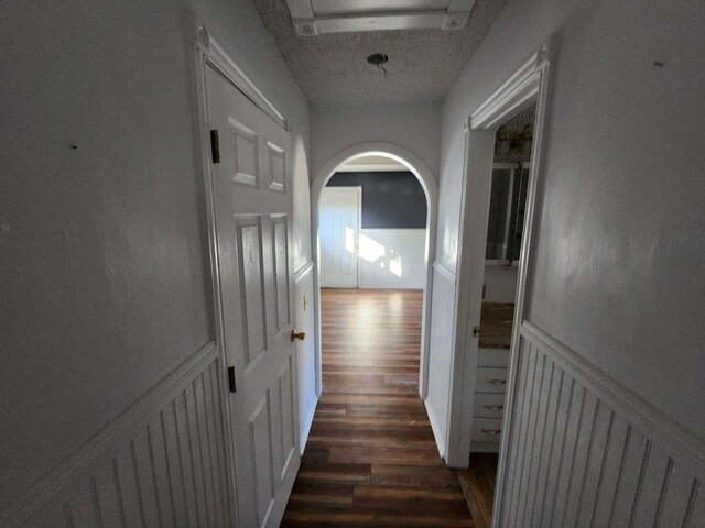 hall with dark hardwood / wood-style floors and a textured ceiling