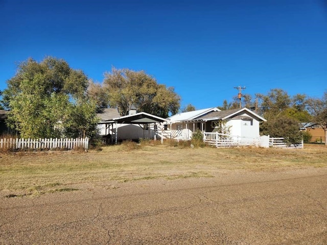 view of front of house with a front lawn and a carport