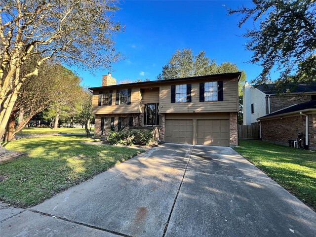 bi-level home with a garage and a front lawn