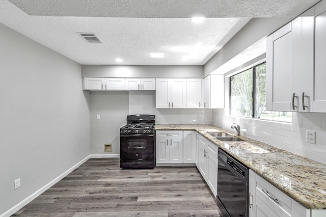 kitchen with black appliances, white cabinets, and wood-type flooring