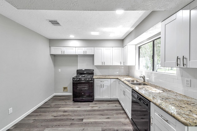 kitchen with sink, black appliances, light stone countertops, a textured ceiling, and white cabinets