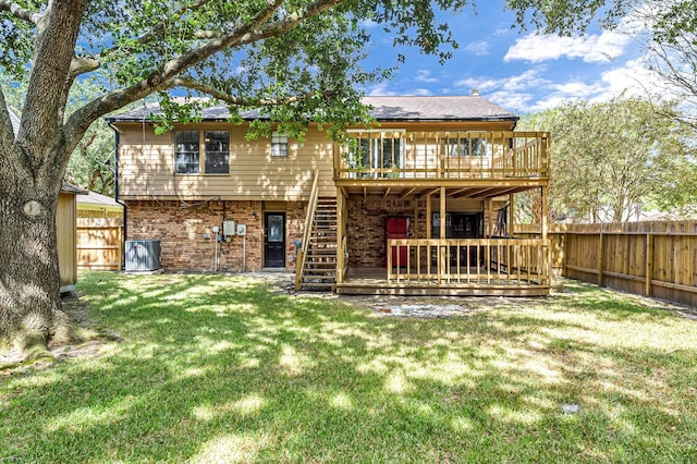 rear view of house featuring cooling unit, a wooden deck, and a lawn