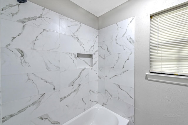 bathroom featuring tiled shower / bath