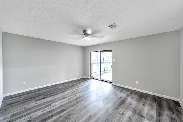 empty room with a textured ceiling, dark wood-type flooring, and ceiling fan