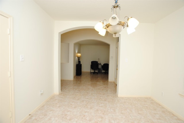 corridor with a notable chandelier and light tile patterned floors