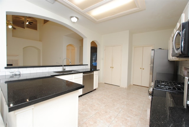 kitchen with appliances with stainless steel finishes, backsplash, ceiling fan, sink, and light tile patterned flooring