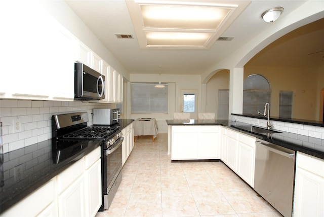 kitchen featuring white cabinets, sink, light tile patterned floors, tasteful backsplash, and stainless steel appliances