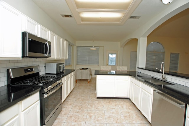 kitchen with white cabinets, sink, appliances with stainless steel finishes, and tasteful backsplash