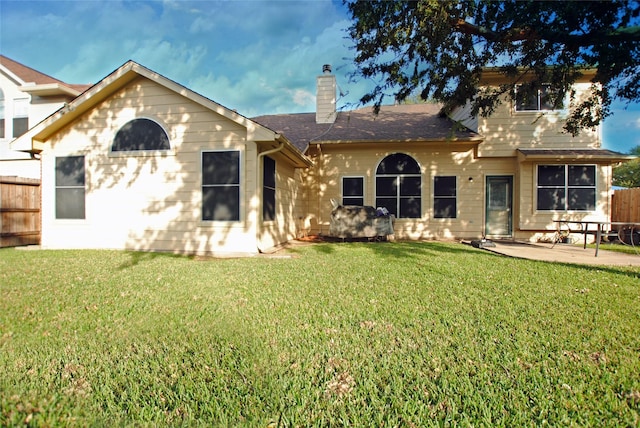 back of house with a lawn and a patio